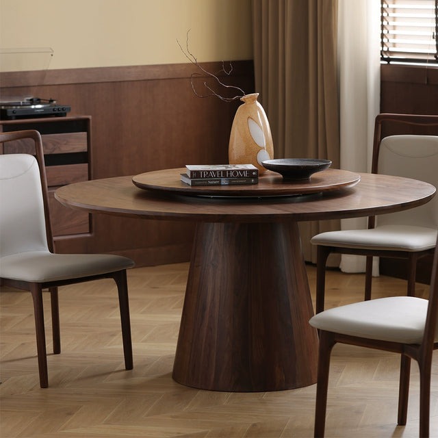 Round wooden dining table with chairs in a cozy dining room.
