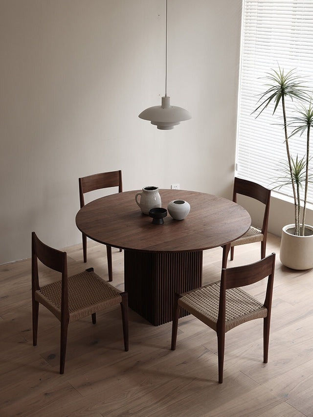 Elegant round dining table with wooden chairs in a modern dining room
