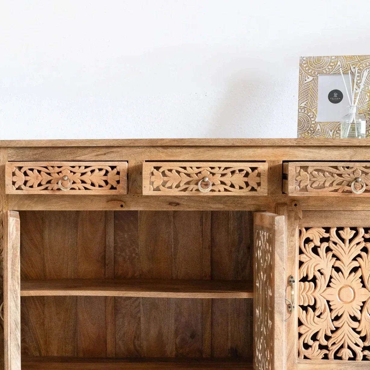 hand carved sideboard, mango wood sideboard, natural finish sideboard, floral carved sideboard, openwork sideboard, 3 door sideboard, 3 drawer sideboard, buffet sideboard, indian carved furniture, storage sideboard, dining room buffet, living room sideboard, entryway sideboard, statement sideboard, medium sideboard, handmade sideboard, artisan made sideboard, premium wood buffet, quality wood furniture, durable sideboard, sturdy buffet, timeless sideboard, elegant buffet, heirloom buffet, rustic sideboard, 