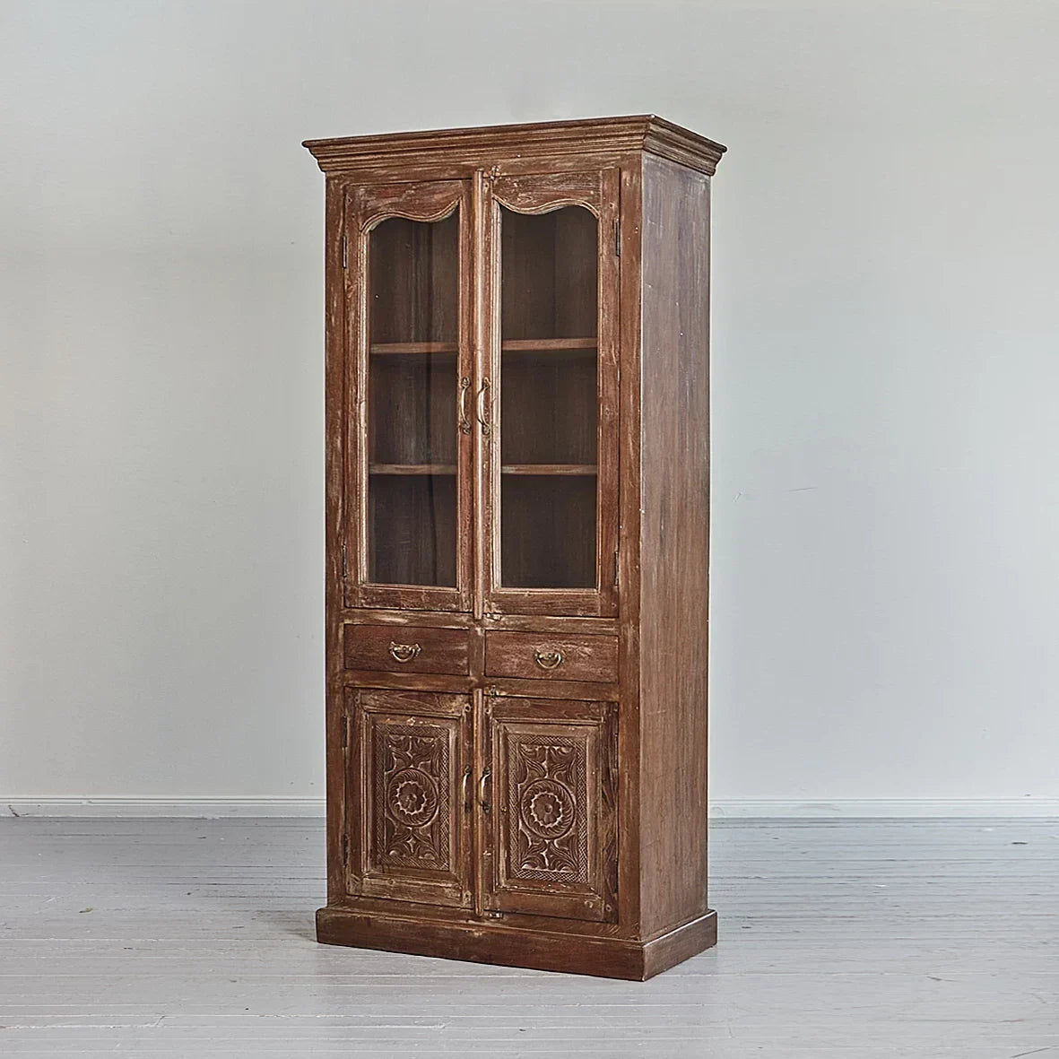 Wooden cabinet with glass doors and decorative elements on a plain background