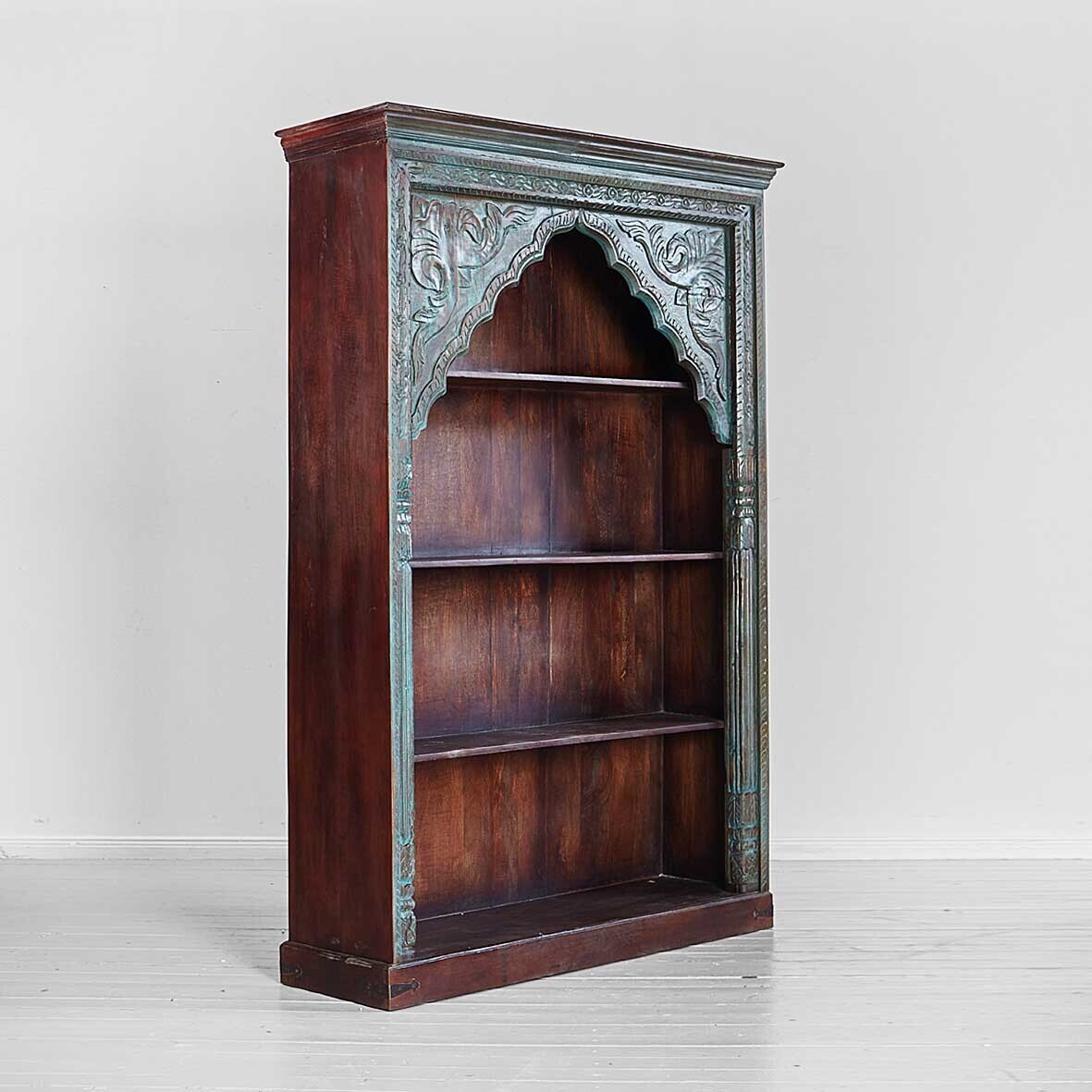 Wooden bookshelf with decorative archway on a white background