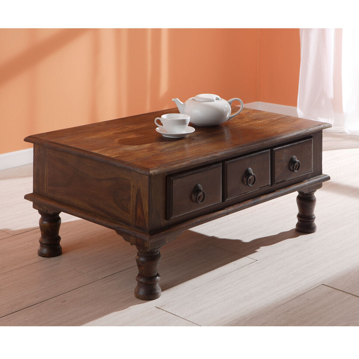 Medium solid rosewood coffee table with three storage drawers and turned legs.