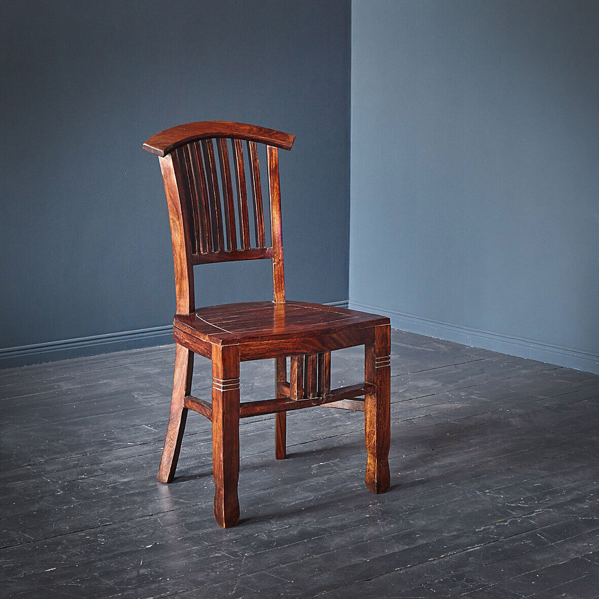 Wooden chair against a gray wall