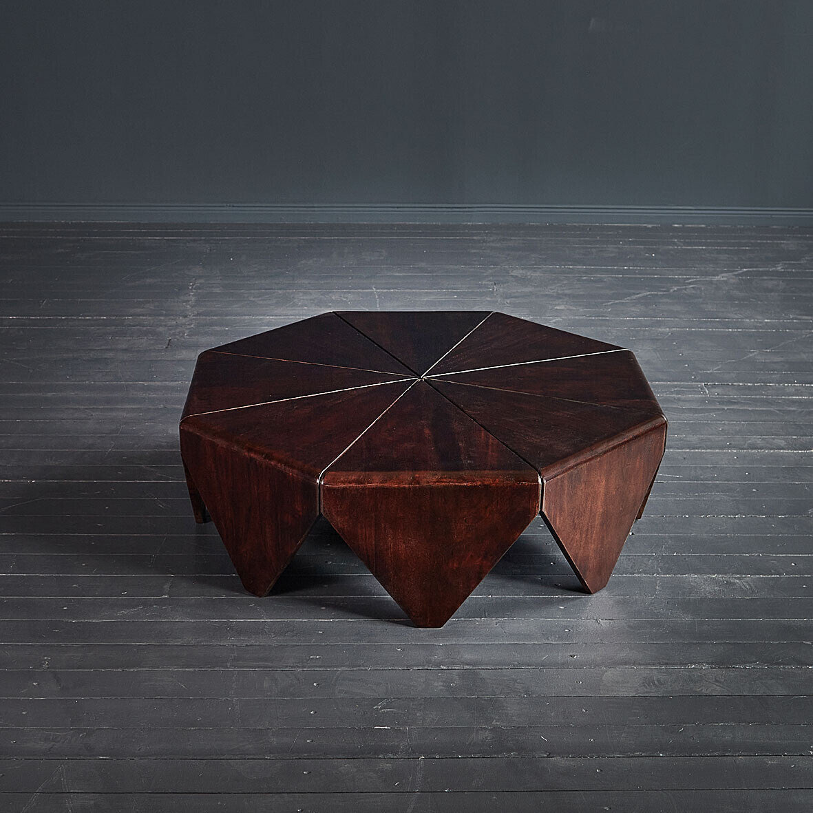 Hexagonal wooden table on a dark wooden floor
