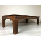 hand carved coffee table, solid wood coffee table, large coffee table, carved wood table, rectangular coffee table, indian furniture, living room table, statement coffee table, handmade coffee table, artisan made table, premium wood table, quality furniture, durable table, sturdy table, timeless table, elegant table, ornate table, unique table, sculptural table, focal piece table, handcrafted in india, sustainable wood furniture, warm wood finish, geometric borders, floral rosettes, scrolling acanthus, six 
