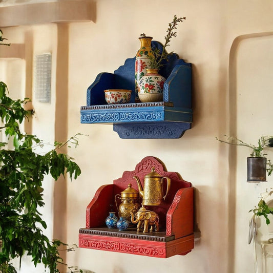 Set of two Jodhpur carved wood temple wall shelves with distressed red and blue finishes, mounted on a wall. Handcrafted in Jodhpur, Rajasthan. Ideal for pooja or decorative display.