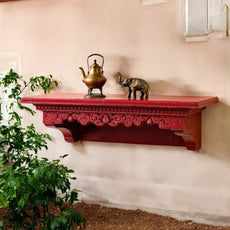 Ethnic living room with large carved wall shelf above a velvet sofa