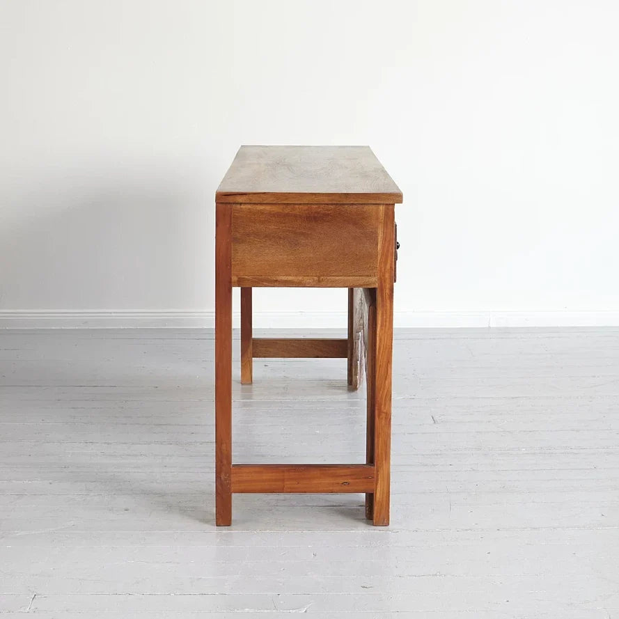 Wooden desk with a single drawer on a white floor and white wall background