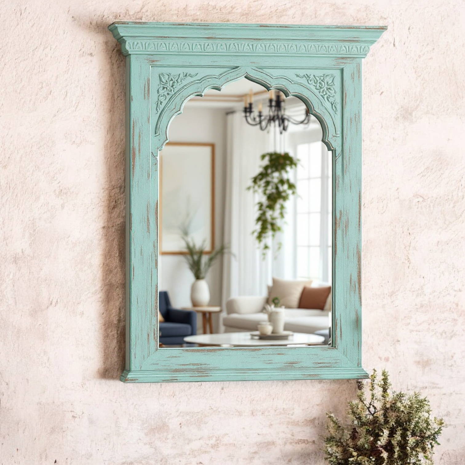 "Jodhpur vintage wall mirror with a carved arch Jharokha design and distressed mint green frame, reflecting a living room interior."

