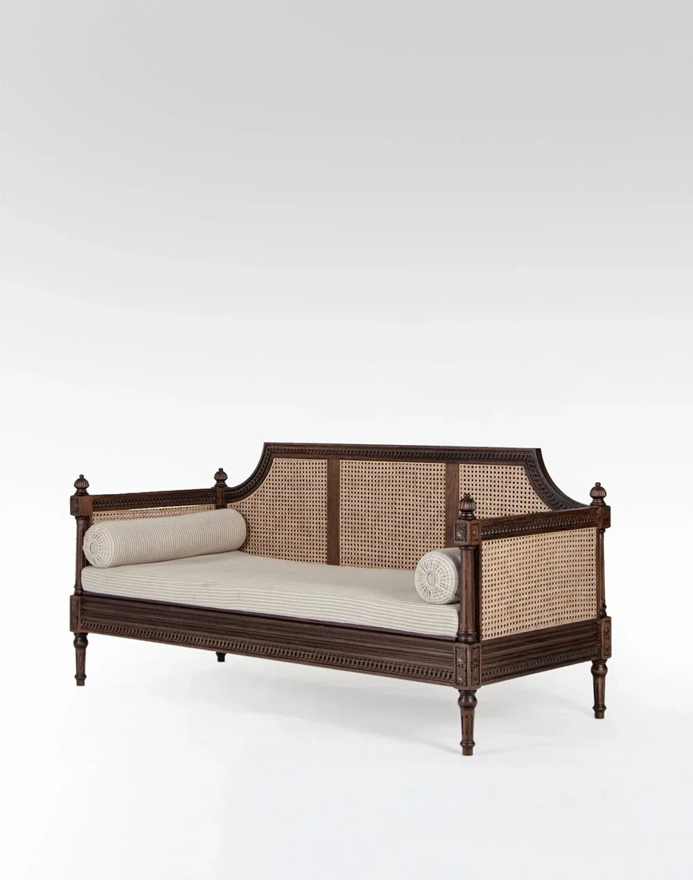 Wooden daybed with woven backrest and white cushions on a white background