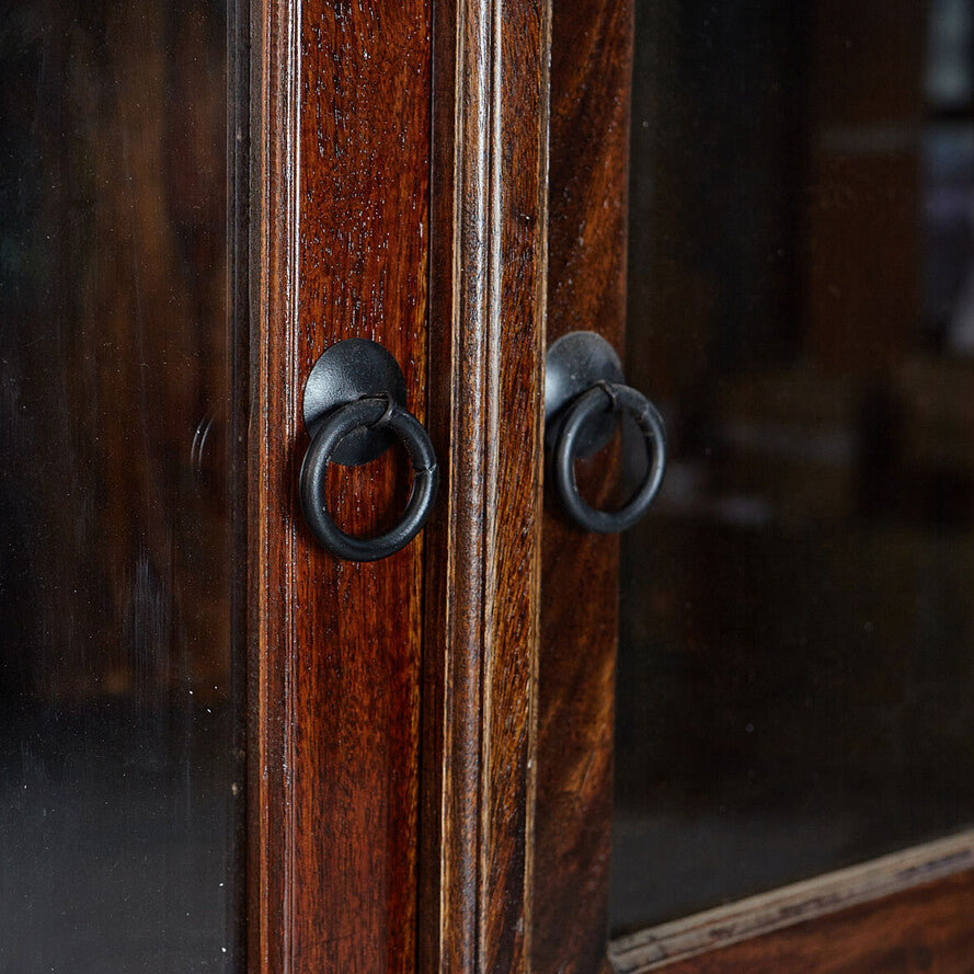 Close-up of a wooden cabinet with metal handles on a dark background