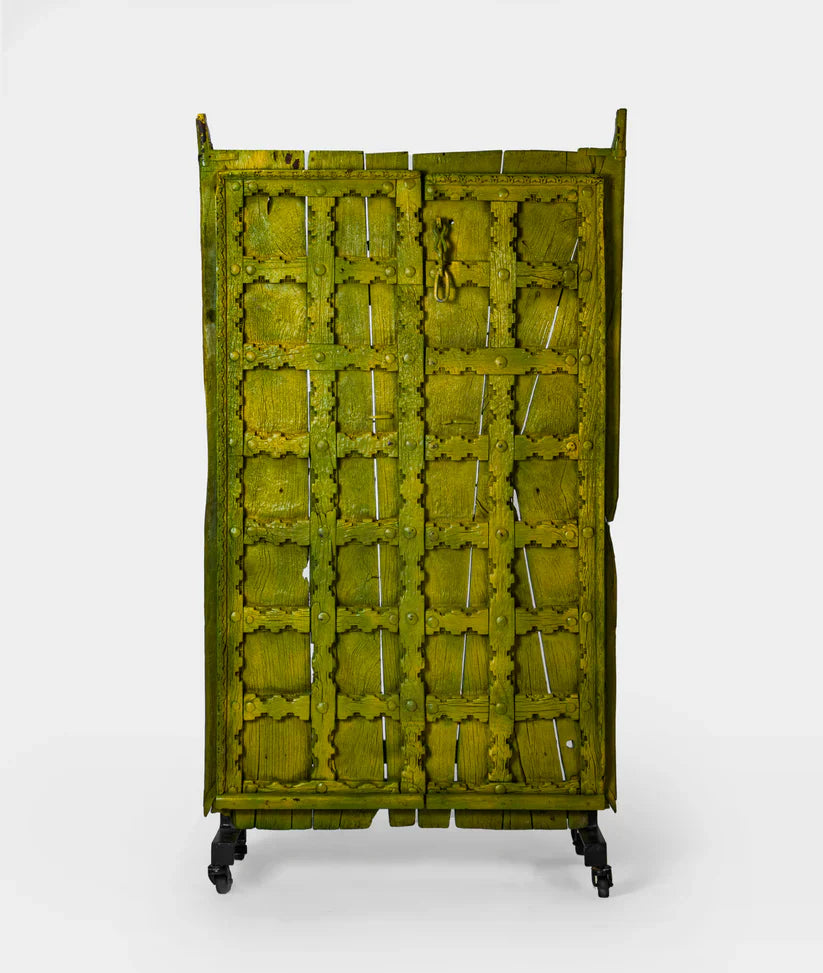 Unique Marwari wooden door with iron stand, distressed olive green finish, 94 × 171 cm.

Handcrafted solid wood Marwari door panel with grid pattern and castor base.

Tall antique-style Indian door decor in olive green, made in India.