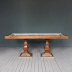 Large 6‑8 seater wooden dining table with carved apron and legs, natural finish.


