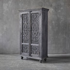 Tall carved wooden storage cabinet with ball feet and ornamental detailing.

