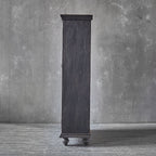 Tall dark wooden cabinet against a gray textured wall
