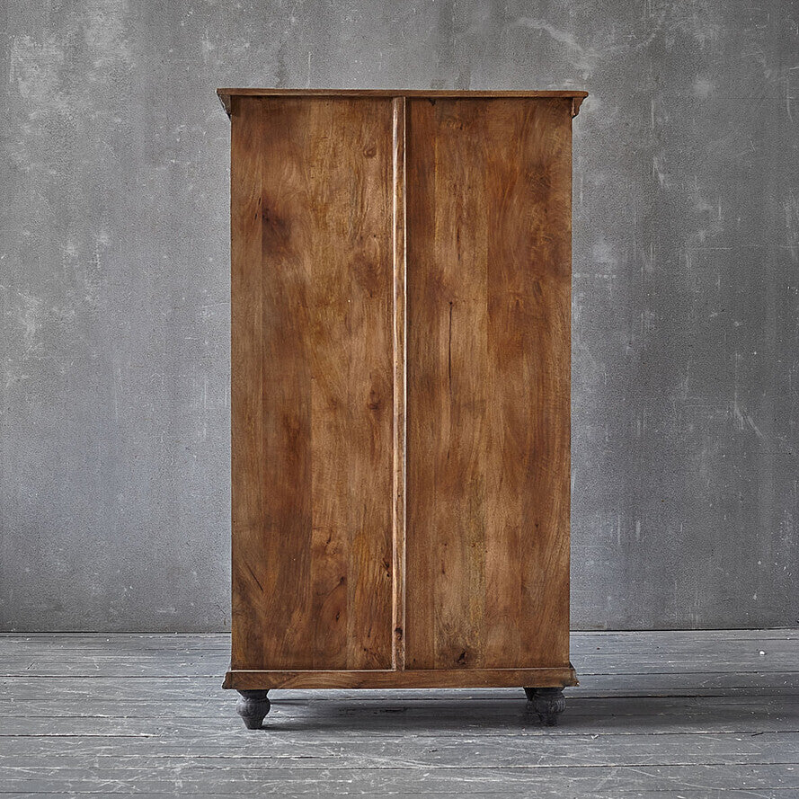Wooden wardrobe with a rustic finish against a gray wall.