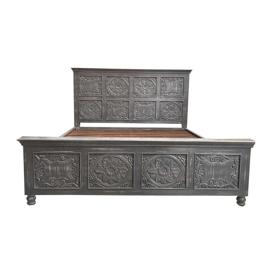 Decorative wooden bed with intricate carvings on a white background
