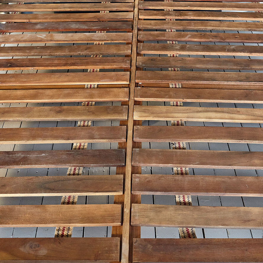 Wooden slatted panel with a grid pattern on a gray surface