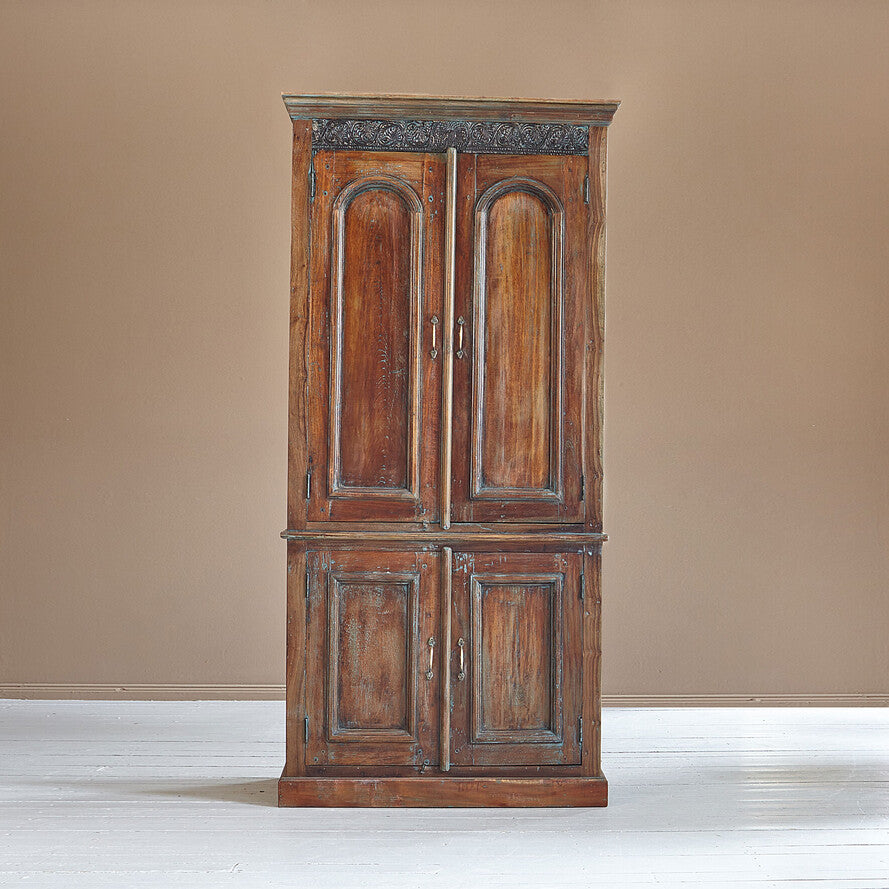 Wooden wardrobe with decorative carvings on a beige background