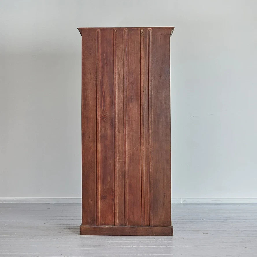 Wooden cabinet with vertical slats on a plain background
