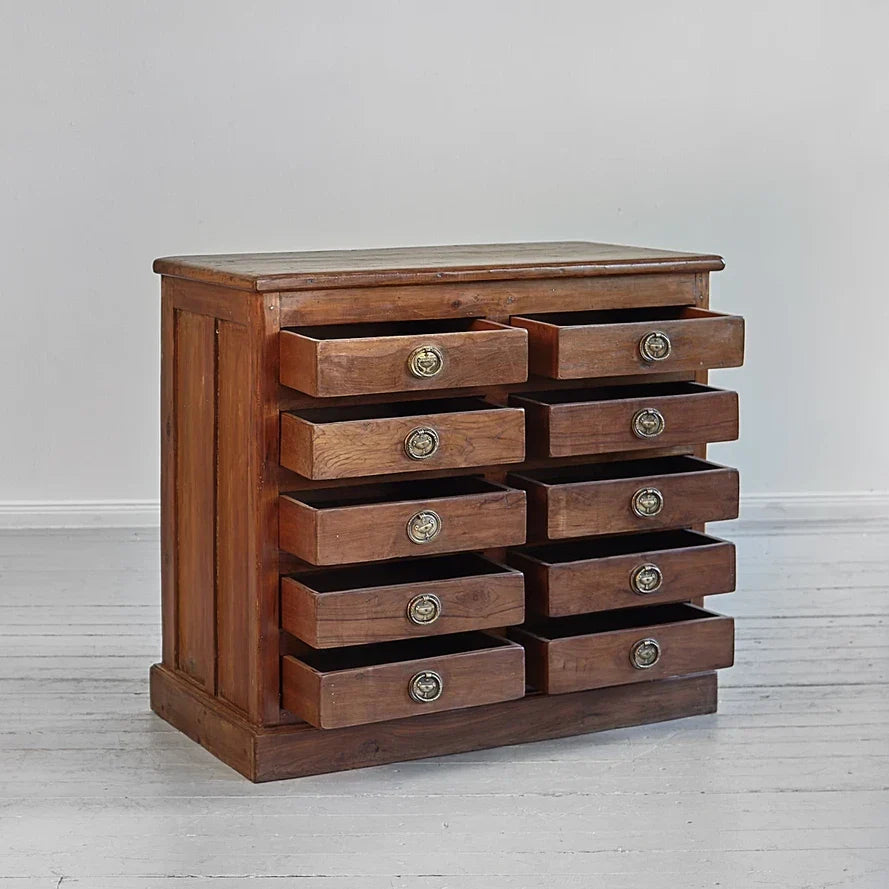 Wooden dresser with multiple drawers on a light gray background