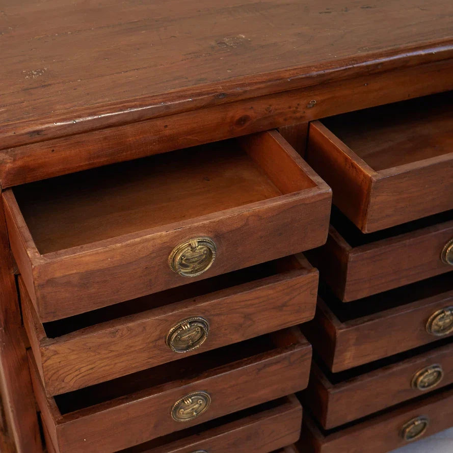 Wooden drawer unit with brass handles on a wooden surface