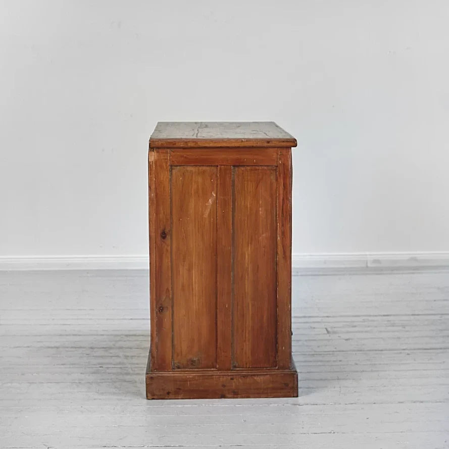 Wooden cabinet with a stone top on a white floor and wall