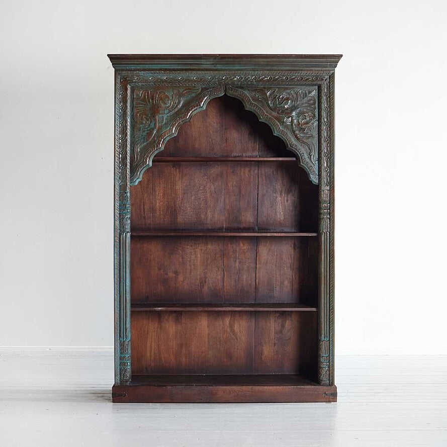 Wooden bookshelf with decorative top on a white background