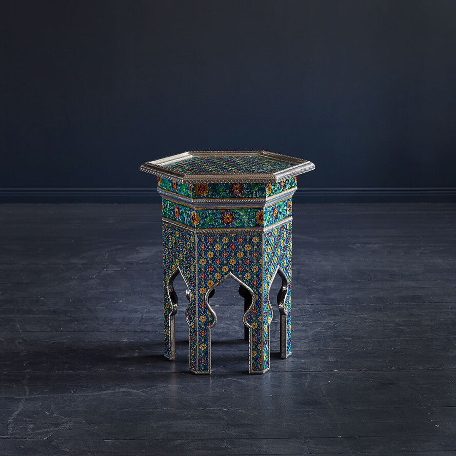 Decorative hexagonal table with intricate patterns on a dark floor and background