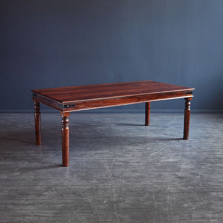 Large solid rosewood dining table with hand-turned legs in a spacious dining room.