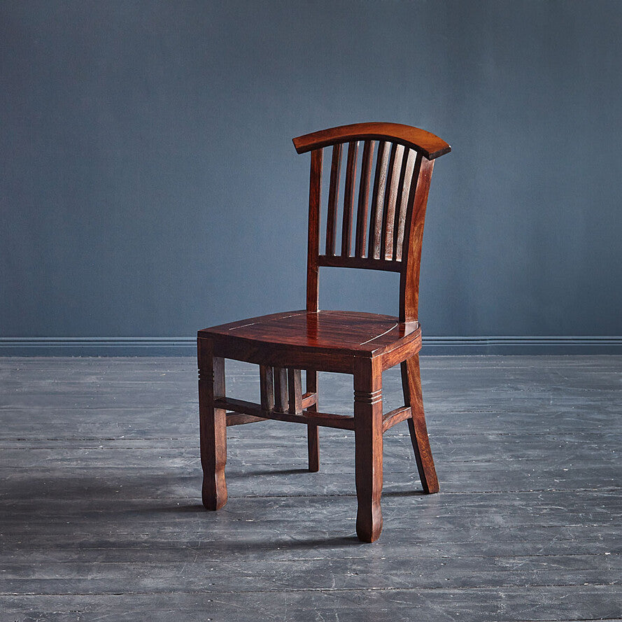 Front view of a solid rosewood dining chair with vertical back slats and a natural finish.