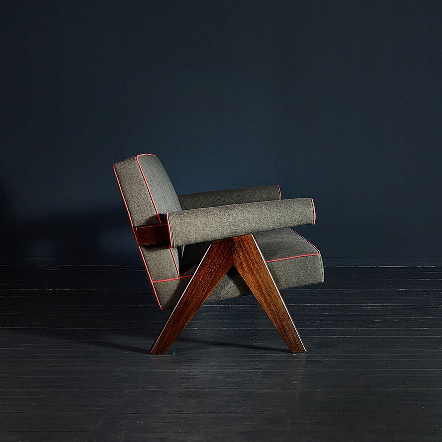 Modern chair with gray upholstery and wooden legs against a dark background