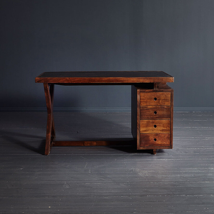 Wooden desk with drawers against a dark gray wall