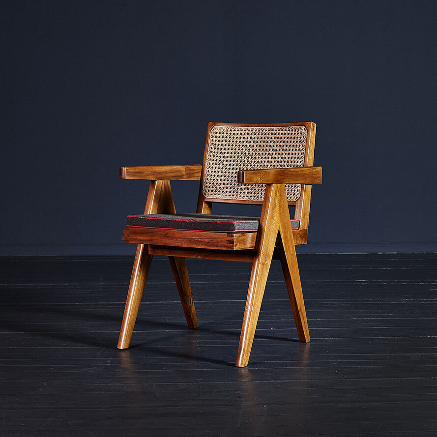 Wooden armchair with woven backrest on a dark floor and background