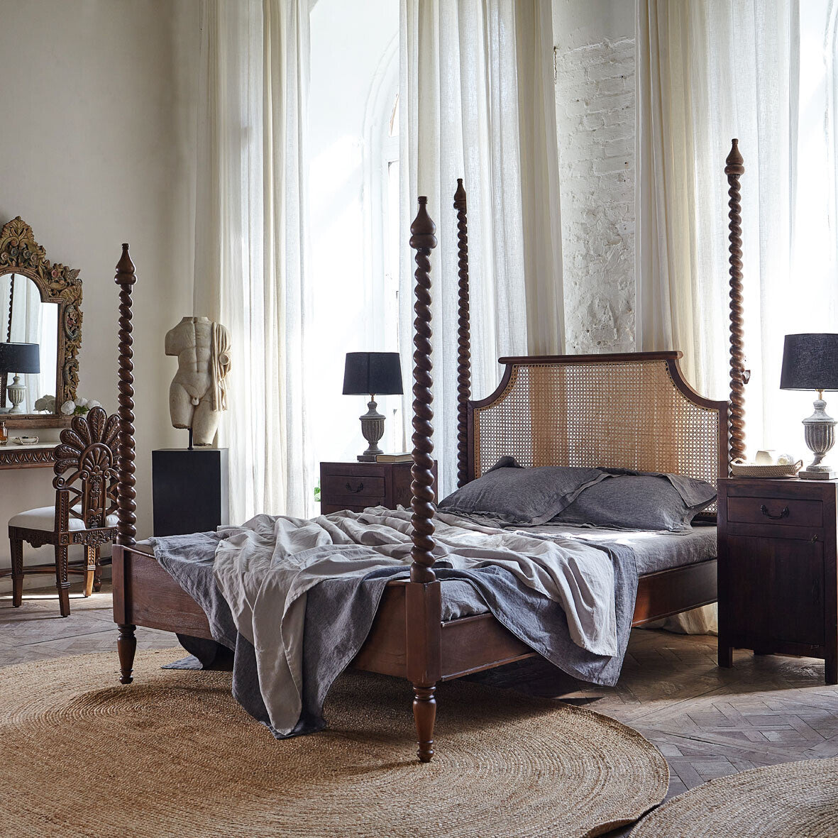 Vintage-style bedroom with wooden four-poster bed, nightstands, and lamps.