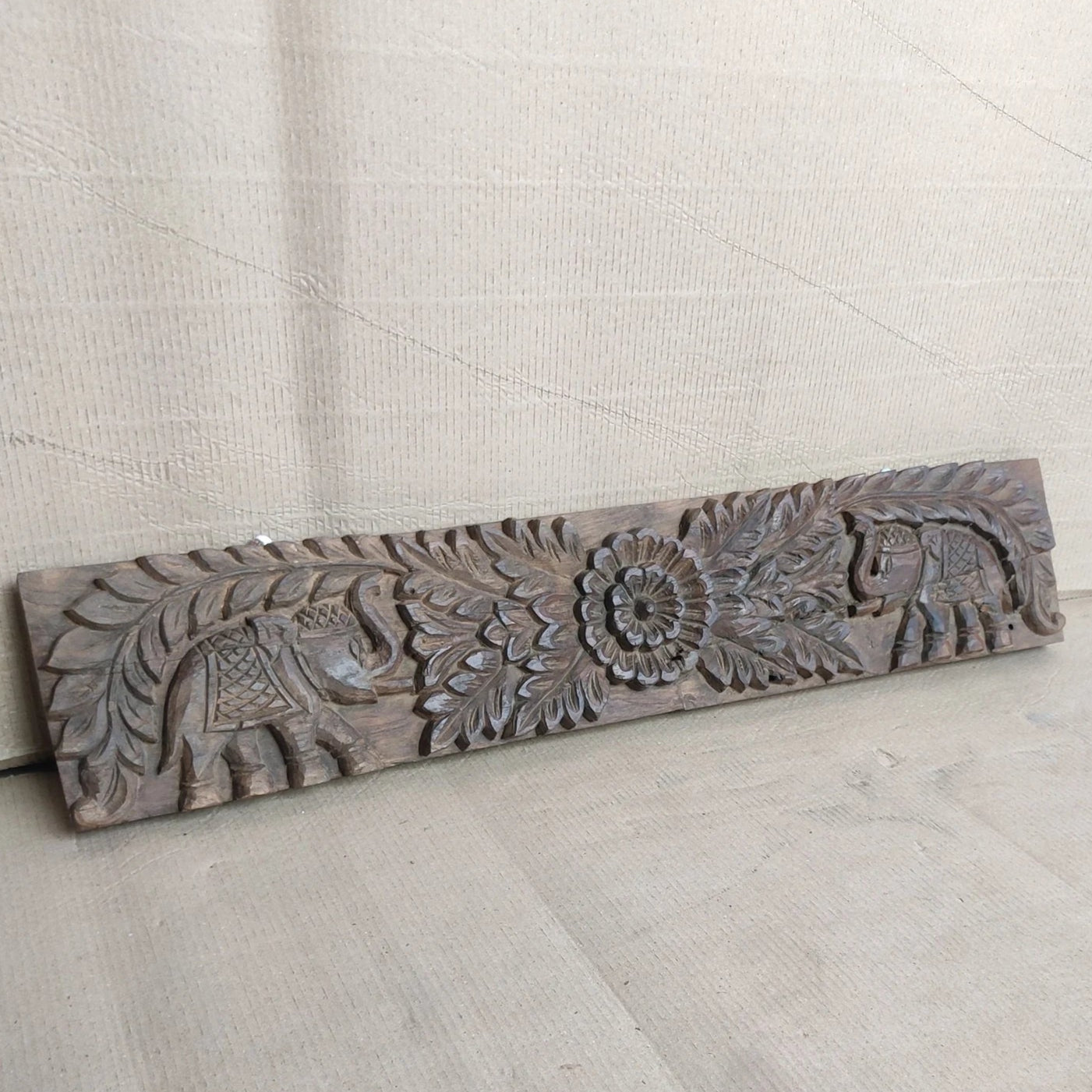 Natural finish teak panel with hand‑carved elephant and floral motifs, 93 × 18 cm.

