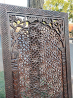 Decorative metal screen with intricate patterns, outdoors.