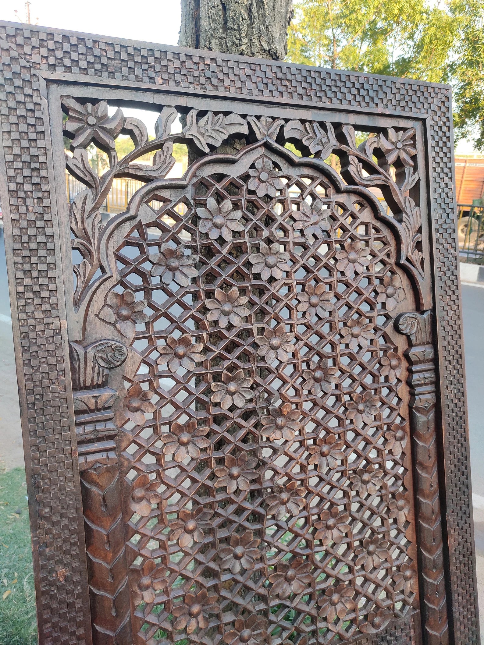 Decorative metal screen with intricate patterns, outdoors.