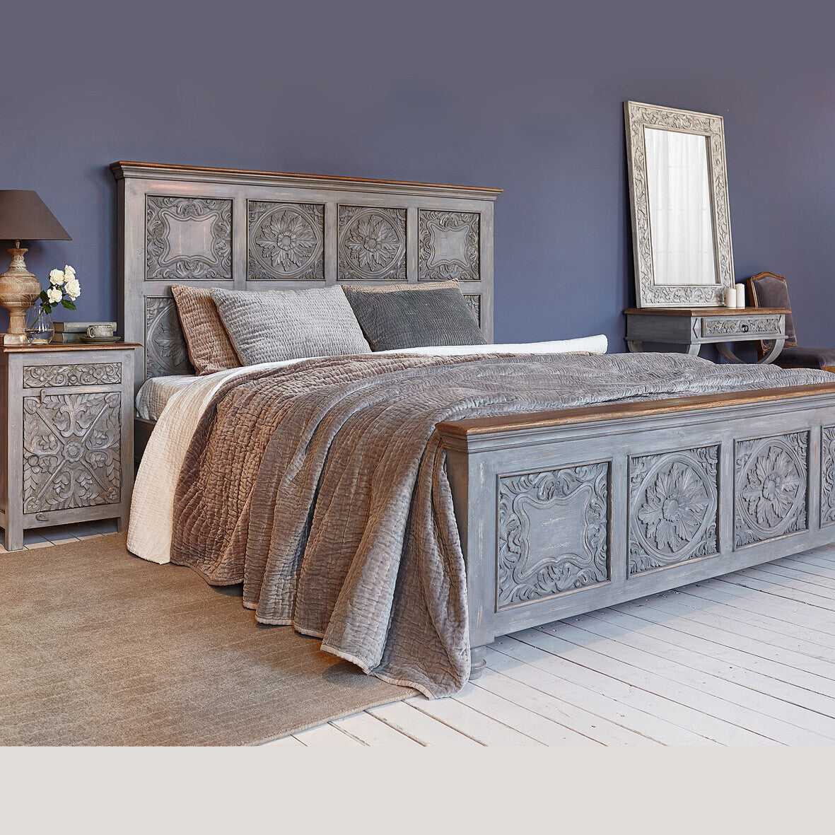 Decorative bedroom with a gray upholstered bed and matching nightstands.