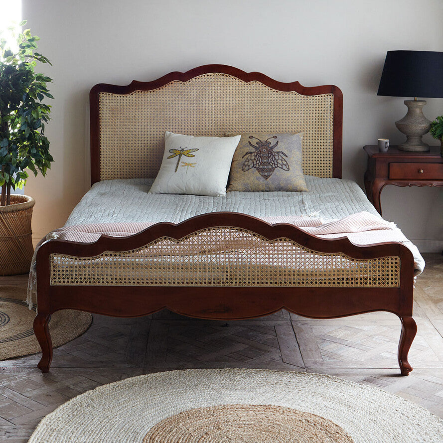 Bedroom with a wooden bed frame and decorative pillows.