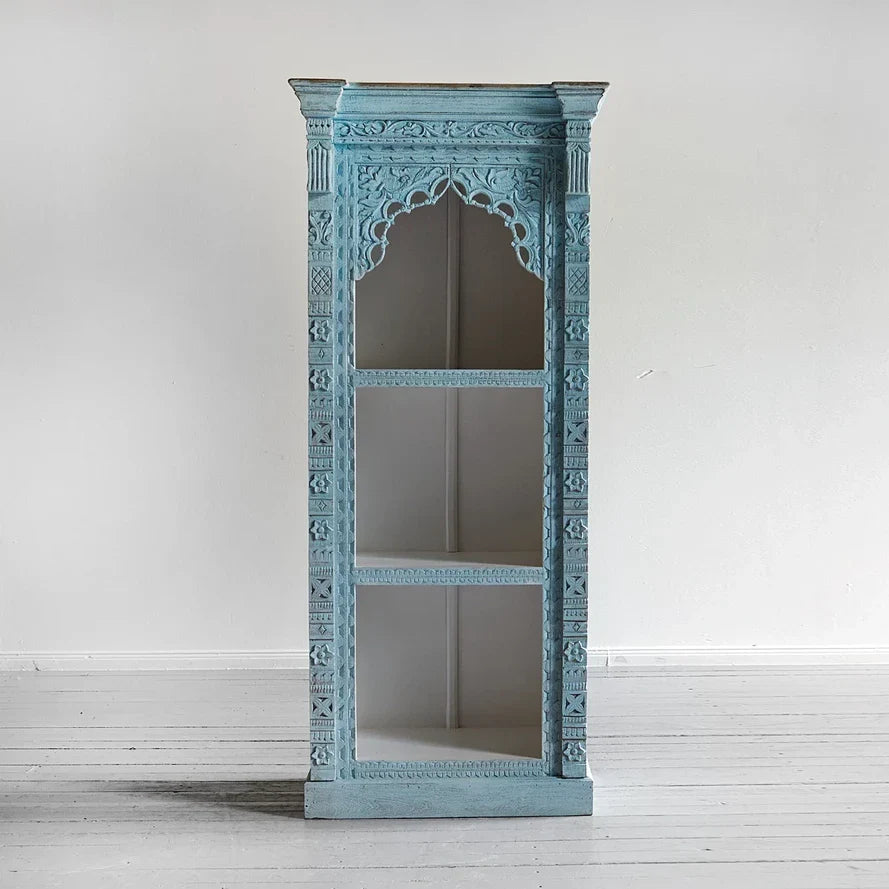 Decorative blue cabinet with intricate carvings on a white background