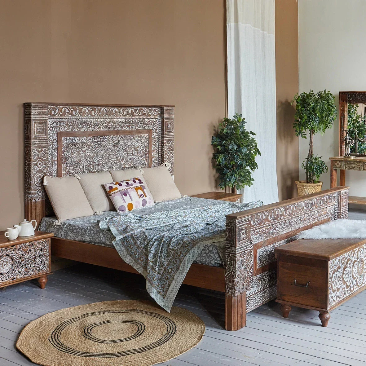 Decorative wooden bed with intricate carvings in a bedroom setting.