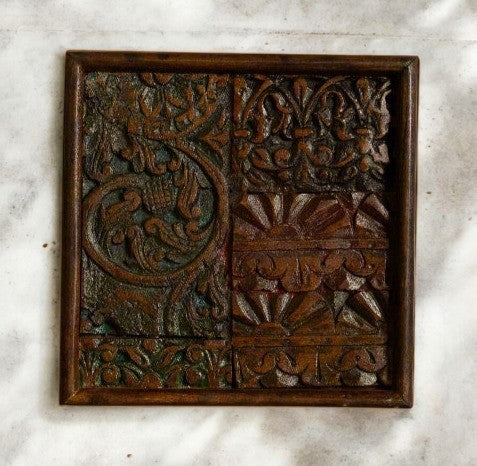 Close-up of intricately carved mango wood wall panel with a wooden frame.

